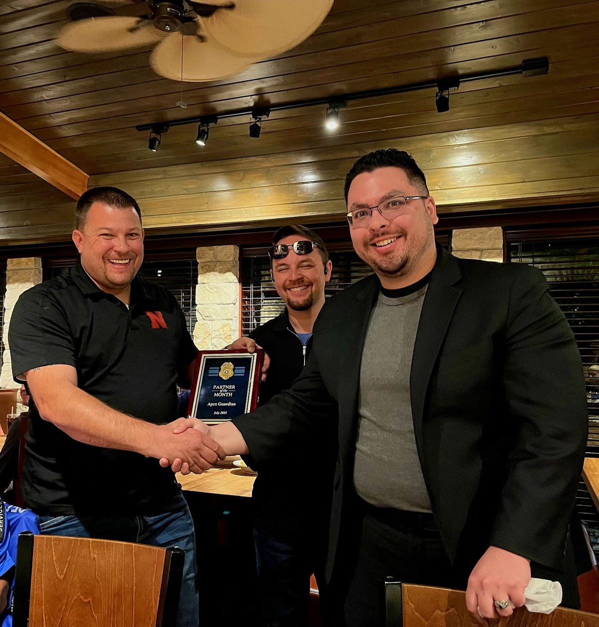 AGN representative receiving a Partner of the Month plaque from a national partner